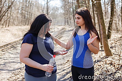 Fit woman dissuade her overweight friend from taking slimming pi Stock Photo