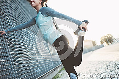 Nice and fit woman doing legs warming exercise, safety stretching before running Stock Photo