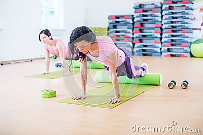 Fit woman doing pilates exercises stretching arching her back at fitness studio Stock Photo