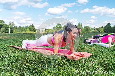 Fit woman doing plank exercise, working on abdominal midsection muscles. Fitness girl core workout in nature. Stock Photo