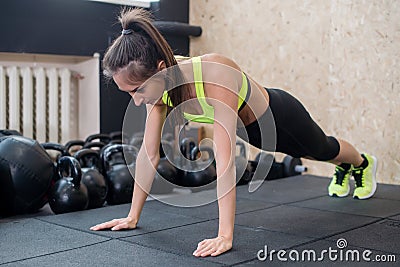 Fit woman doing push-ups on the floor, sporty female working out abs, arm muscles Stock Photo