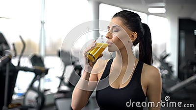 Fit woman drinking refreshing juice from glass after gym workout, health care Stock Photo