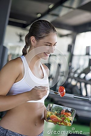 Fit woman eating healthy salad after workout Stock Photo