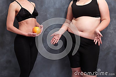 Fit woman with grapefruit and starving overweight lady. Anorexia Stock Photo