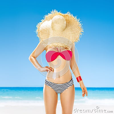 Fit woman hide behind straw hat on seashore applying sun cream Stock Photo