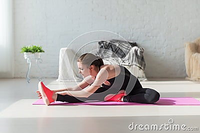 Fit woman high body flexibility stretching her leg Stock Photo