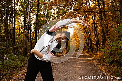 Fit woman in sportswear does side bends outdoor in autumn. Fitness, active morning, training and healthy lifestyle. Park Stock Photo