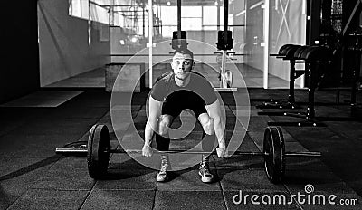 Fit young athlete lifting the barbell in gym. Gym training. Stock Photo