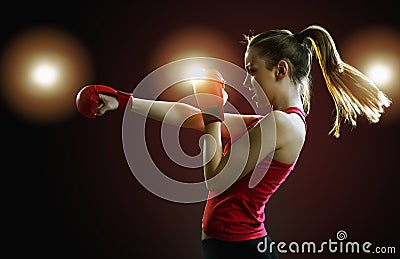 Fit, young, energetic woman boxing, black background Stock Photo