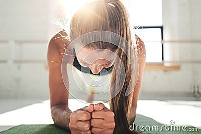 Fit young woman doing plank workout to improve her abs. Female in the gym doing crossfit Stock Photo