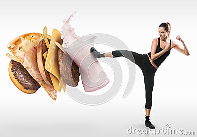 Fit young woman fighting off fast food Stock Photo