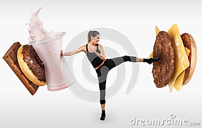 Fit young woman fighting off fast food Stock Photo
