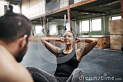 Young woman doing sit ups with her male gym partner Stock Photo