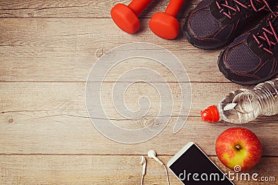 Fitness background with bottle of water, dumbbells and athletic shoes. View from above Stock Photo