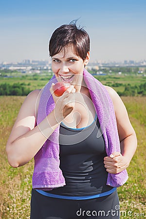 Fitness beautiful plus size woman eating apple Stock Photo