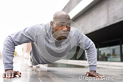 Fitness black man exercising push ups in urban background Stock Photo