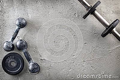 Fitness or bodybuilding background. Old iron dumbbells on conrete floor in the gym. Photograph taken from above, top Stock Photo