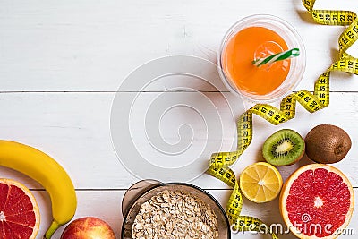 Fitness concept with fruit, a glass of juice and centimeter. Top view background concept. Stock Photo