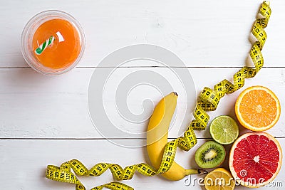 Fitness concept with fruit, a glass of juice and centimeter. Top view background concept. Stock Photo