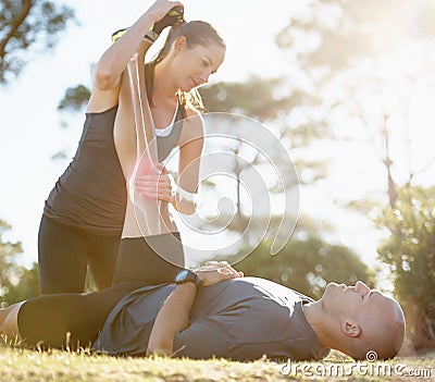 Fitness, couple and helping or stretching leg for healthcare, pain or ache after running workout in nature. Happy woman Stock Photo