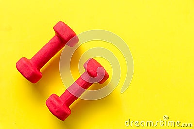 Fitness dumbbell sports equipment top view, yellow color background. Stock Photo