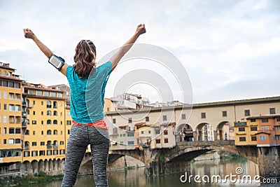 Fitness female rejoicing in front of Ponte Vecchio, Italy Stock Photo