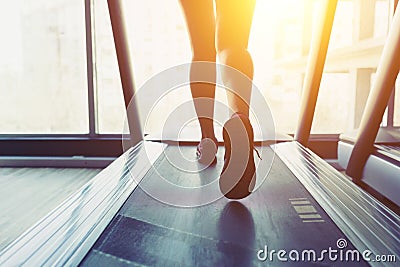 Fitness girl running on treadmill Stock Photo