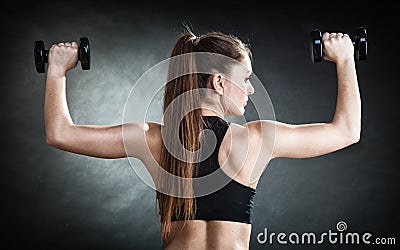 Fitness girl training shoulder muscles lifting dumbbells back view Stock Photo