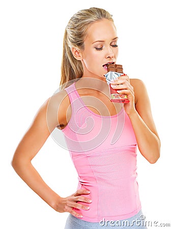 Fitness, health and studio with woman and chocolate bar for unhealthy food choice to indulge for sweetness. Female Stock Photo