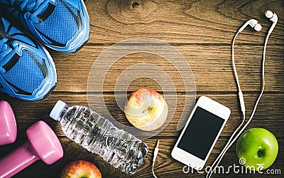 Fitness, healthy and active lifestyles Concept, Bottle of water, dumbbells, sport shoes, smartphone with headphone and apples on Stock Photo