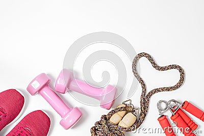 Fitness, healthy and active lifestyles love concept, dumbbells, sport shoes and jump rope in heart shape on white background. Top Stock Photo