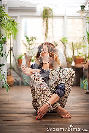 Fitness home exercise concept. A woman practices yoga and Pilates at home. Eco friendly house. Urban Jungle and Yoga. Stock Photo