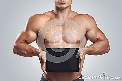 Fitness male holding horizontally digital tablet with blank scre Stock Photo