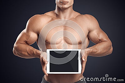 Fitness male holding horizontally digital tablet with blank scre Stock Photo