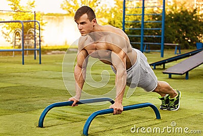 Fitness man doing push-ups in the stadium, cross training workout. Sporty male training outside Stock Photo