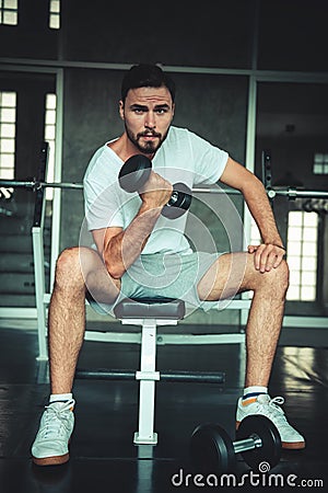 Fitness man is exercising dumbbell lifting in gym., Portrait of caucasian handsome man doing weightlifting and workout for healthy Stock Photo