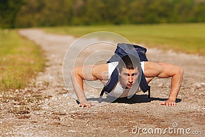 Fitness man exercising push ups, outdoor. Muscular male cross-training outside Stock Photo