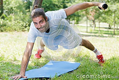 fitness man training dumbbells plank outdoors Stock Photo