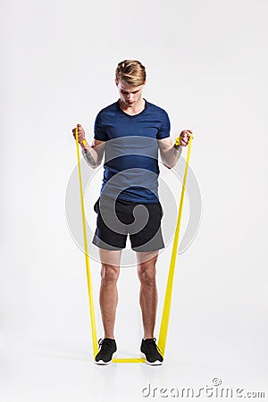 Fitness man working out with resistance bands, studio shot. Stock Photo