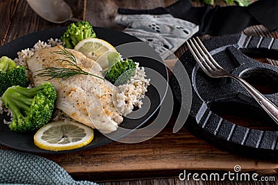 Fitness meal with seared fish fillet, brown rice and broccoli on a plate Stock Photo