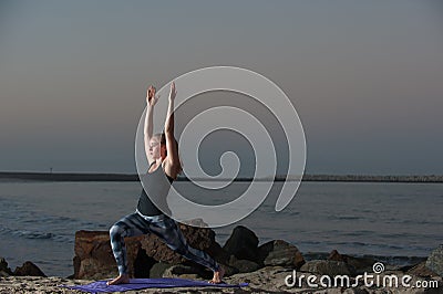 Fitness model performs side reaching lunge. Stock Photo