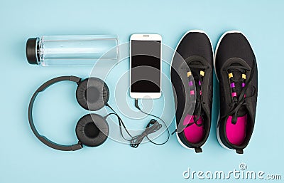 Fitness objects on blue background. Sneakers, water and audioplayer Stock Photo