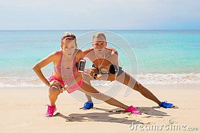 Fitness pals streching after workout on the beach Stock Photo