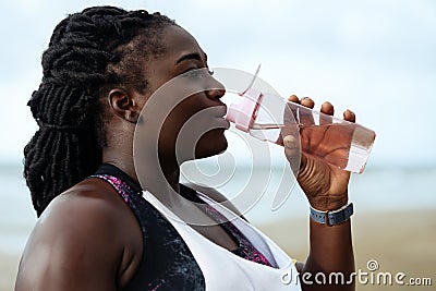 Fitness, people and healthy lifestyle- african woman drinking water after sport Stock Photo