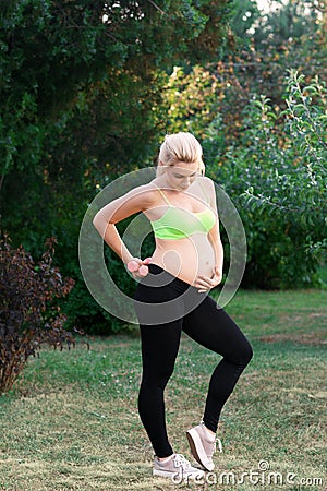 Fitness pregnant woman feeling her baby push Stock Photo