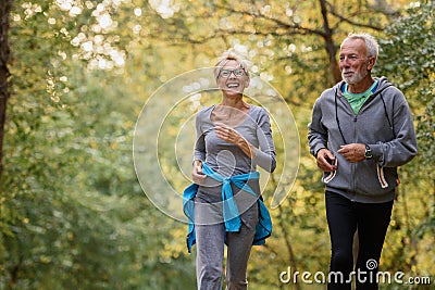 Cheerful active senior couple jogging in the park Stock Photo