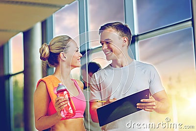 Smiling young woman with personal trainer in gym Stock Photo