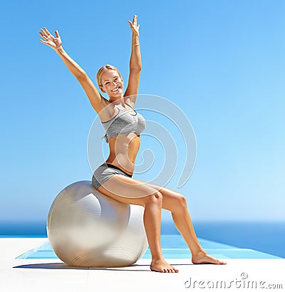 Fitness starts and ends with your core. Portrait of an attractive young woman working out with an exercise ball by a Stock Photo