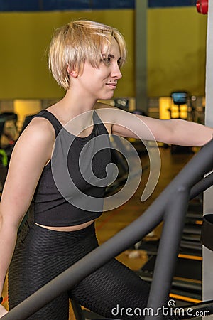 Fitness walks on the simulator stairs ladder simulator active personal, in the afternoon physical shorts from trainer Stock Photo