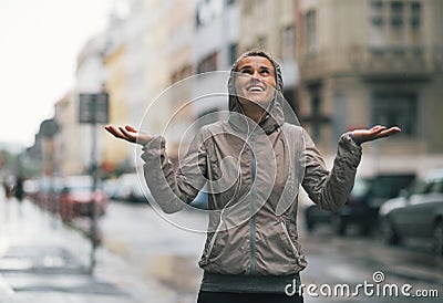 Fitness woman catching rain drops in the city Stock Photo